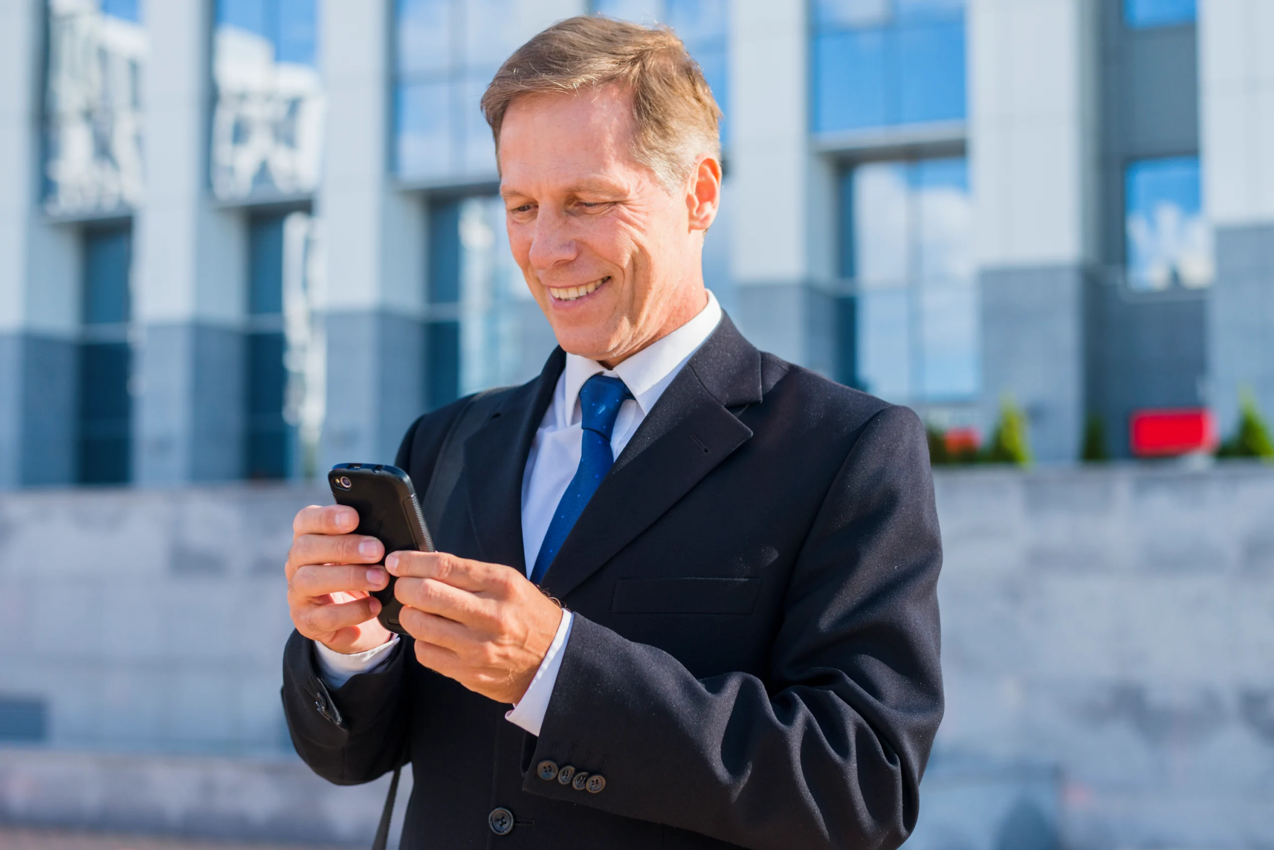 smiling-mature-businessman-using-smartphone