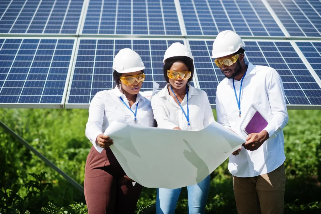 three peoples in front of a solar panel